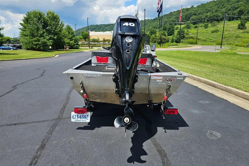 Slide: The Image of 2016 Tracker PRO160 boat with outboard motor on a trailer, parked on asphalt. - 2