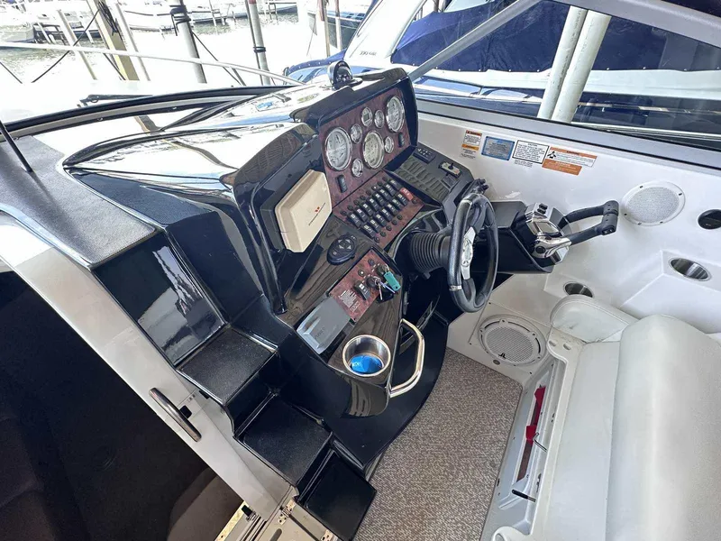 Slide: The Image of 2014 Rinker 310 Express Cruiser helm with steering wheel and control panel. - 13