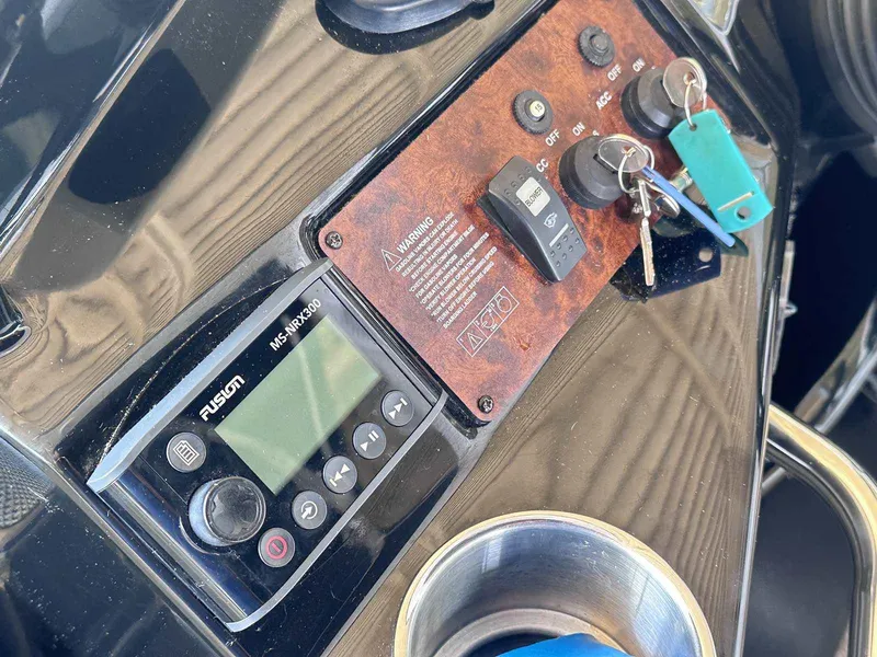 Slide: The Image of 2014 Rinker 310 Express Cruiser interior with seating, wood paneling, and porthole window. - 22