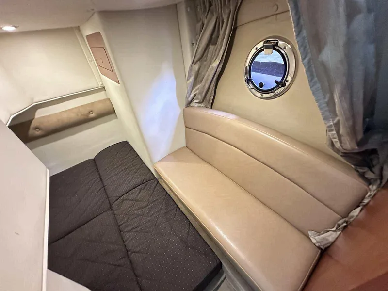 Slide: The Image of Interior of a 2014 Rinker 310 Express Cruiser with wooden cabinetry and seating. - 24