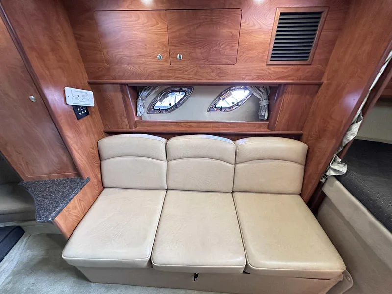 Slide: The Image of 2014 Rinker 310 Express Cruiser interior with beige convertible seating. - 32