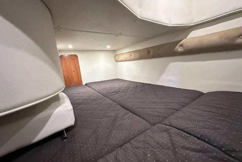 Slide: The Image of Interior cabin of 2014 Rinker 310 Express Cruiser with cozy bedding and wooden door. - 33