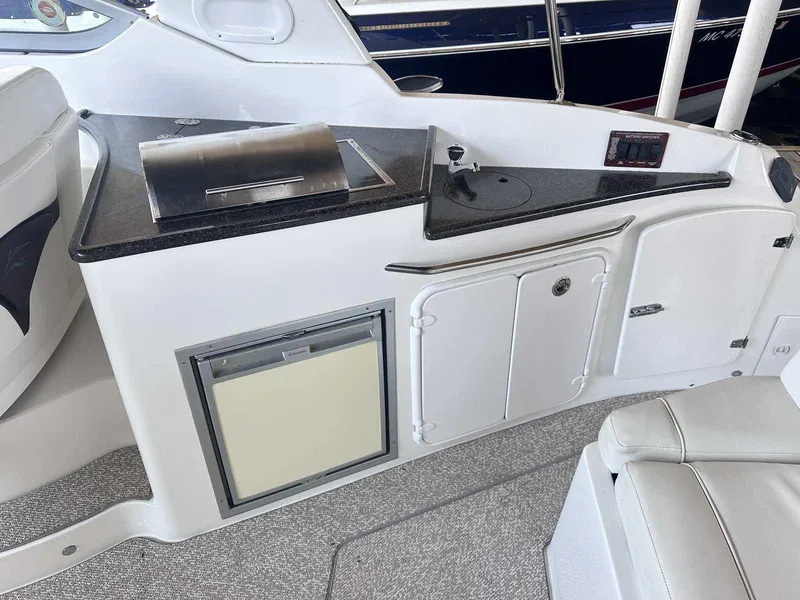 Slide: The Image of Storage compartment on a 2014 Rinker 310 Express Cruiser with black fenders inside. - 4