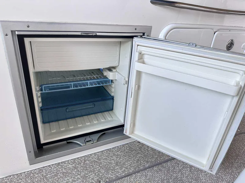 Slide: The Image of 2014 Rinker 310 Express Cruiser interior with kitchenette and seating area. - 5