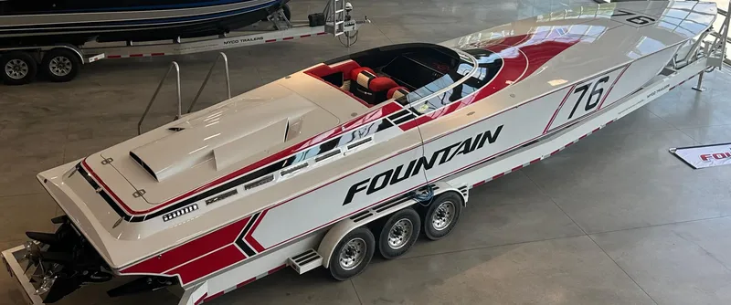 The Image of 1993 Fountain 47 powerboat with red and white design, displayed indoors on a trailer. - 1