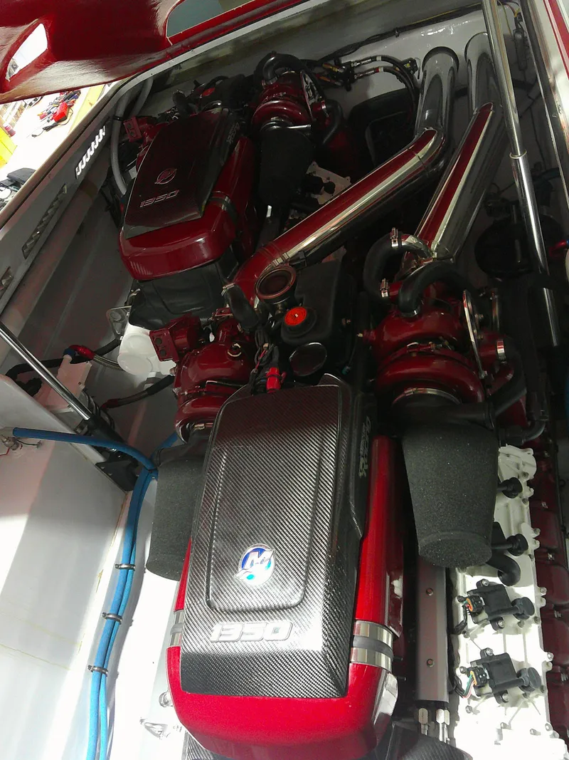 Slide: The Image of Engine compartment of a 1993 Fountain 47 boat, featuring red and black components. - 12