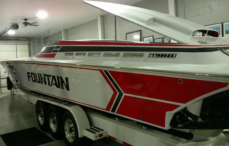 Slide: The Image of 1993 Fountain 47 speedboat with red and white design on a trailer in a garage. - 5