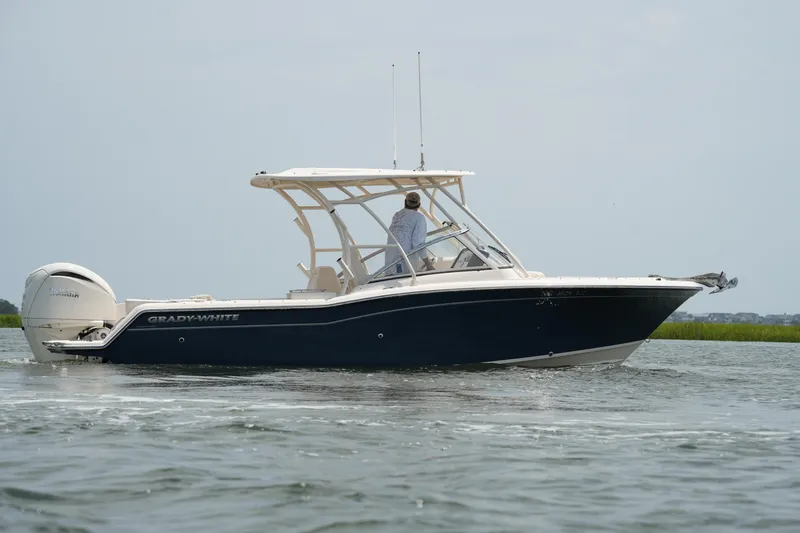 Slide: The Image of 2023 Grady-White Freedom 235 boat cruising on calm water. - 12