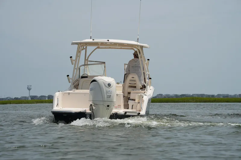 Slide: The Image of 2023 Grady-White Freedom 235 boat cruising on water, rear view. - 15