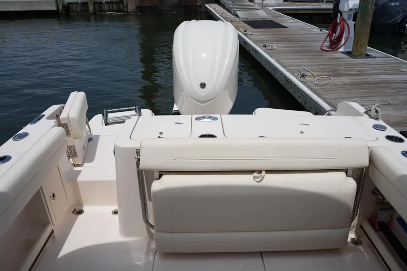 Slide: The Image of 2023 Grady-White Freedom 235 boat interior with seating and motor, docked at marina. - 19