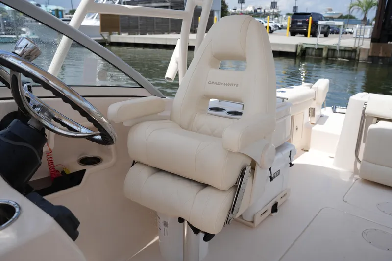 Slide: The Image of 2023 Grady-White Freedom 235 boat interior with luxurious captain's chair and steering wheel. - 26