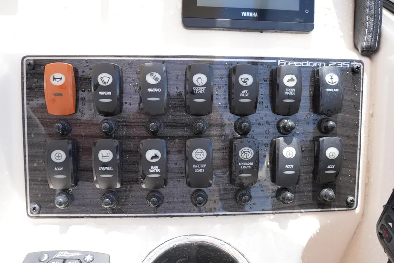 Slide: The Image of Control panel of 2023 Grady-White Freedom 235 boat with labeled switches. - 31