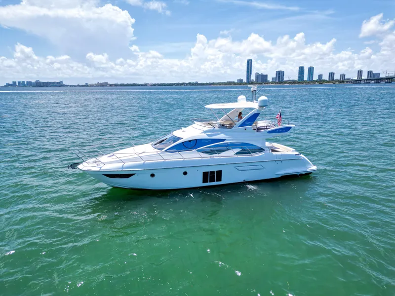 The Image of 2015 Azimut 54 Fly yacht cruising on clear blue water under a sunny sky. - 1
