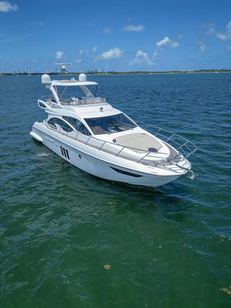 Slide: The Image of 2015 Azimut 54 Fly yacht cruising on clear blue waters under a sunny sky. - 21