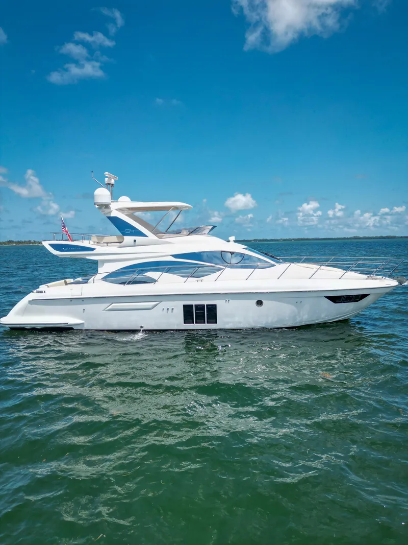 Slide: The Image of 2015 Azimut 54 Fly yacht cruising on open water under clear blue skies. - 22