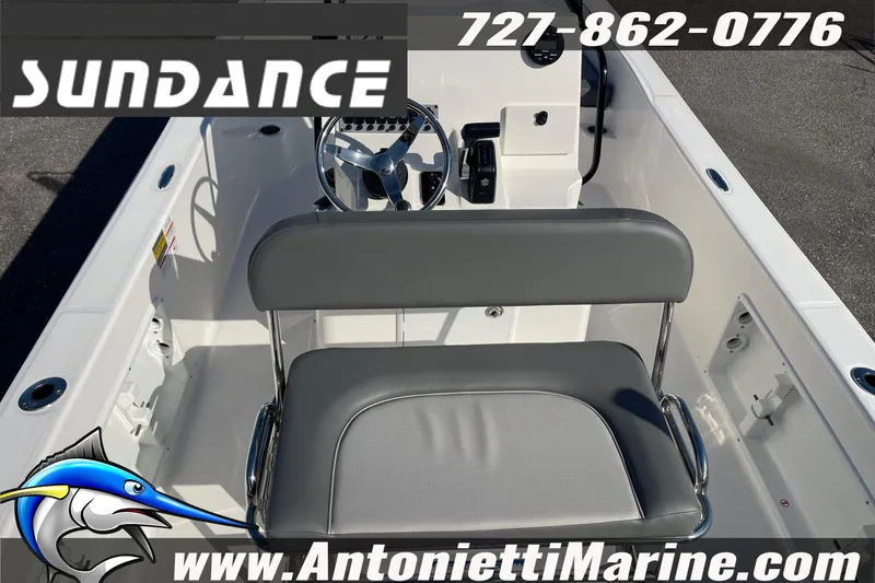Slide: The Image of 2025 Sundance DX20 boat interior with gray seating and steering wheel, Antonietti Marine branding. - 13