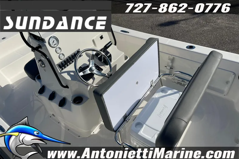 Slide: The Image of 2025 Sundance DX20 boat interior with steering console and storage compartment. - 15