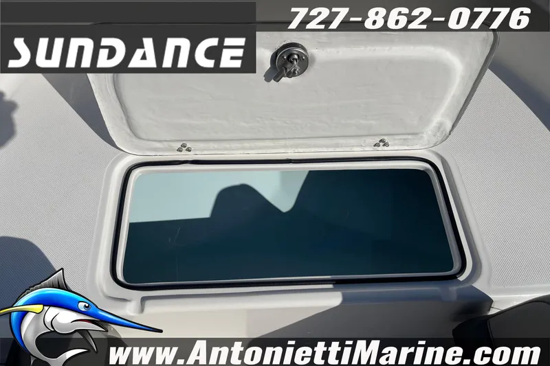 Slide: The Image of Open storage compartment on 2025 Sundance DX20 boat, featuring secure latch and sleek design. - 25