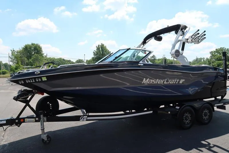 Slide: The Image of 2019 MasterCraft XT22 boat on trailer under clear sky. - 3