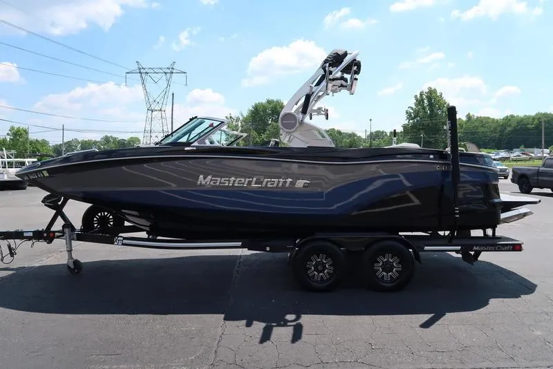 Slide: The Image of 2019 MasterCraft XT22 boat on trailer under clear blue sky. - 5