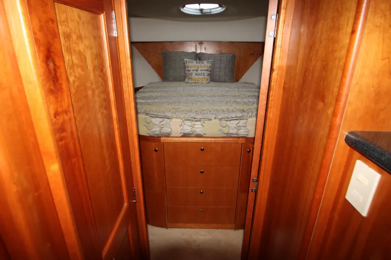 Slide: The Image of Interior cabin of 2002 Silverton 43 Motor Yacht with wooden cabinetry and cozy bedding. - 12
