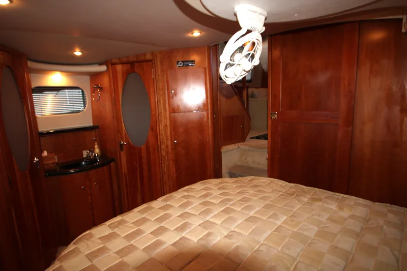 Slide: The Image of Luxurious cabin interior of 2002 Silverton 43 Motor Yacht with wood paneling and cozy bed. - 38