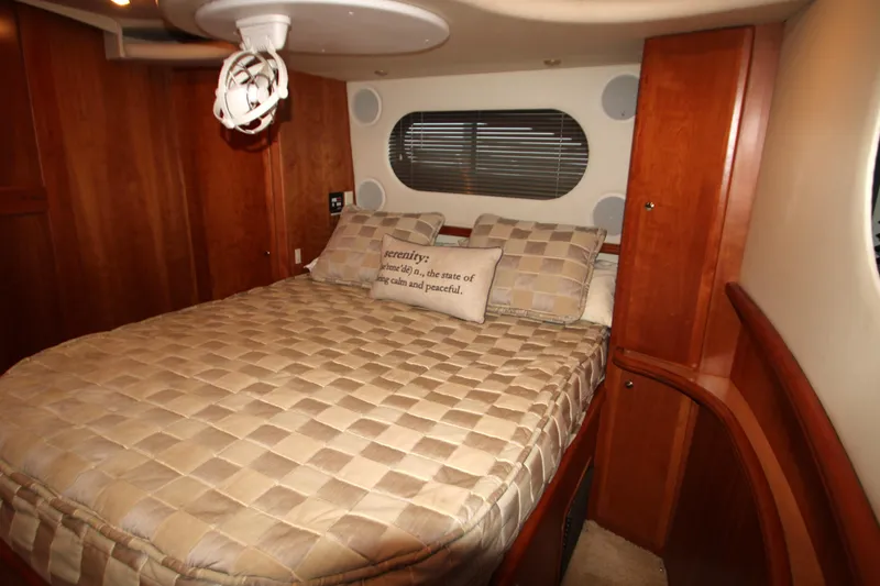 Slide: The Image of Luxurious bedroom interior of 2002 Silverton 43 Motor Yacht with wood paneling and cozy bedding. - 39