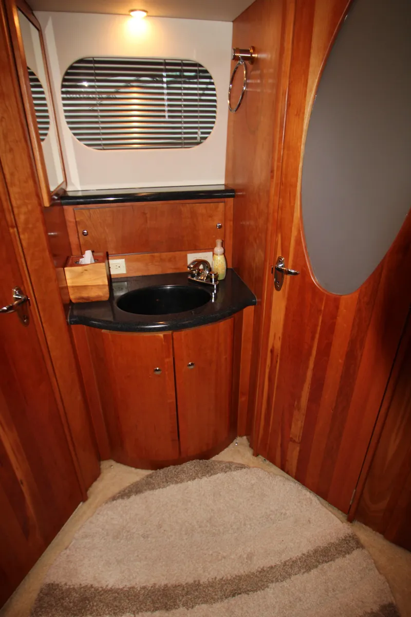 Slide: The Image of 2002 Silverton 43 Motor Yacht bathroom with wood cabinetry and oval mirror. - 42