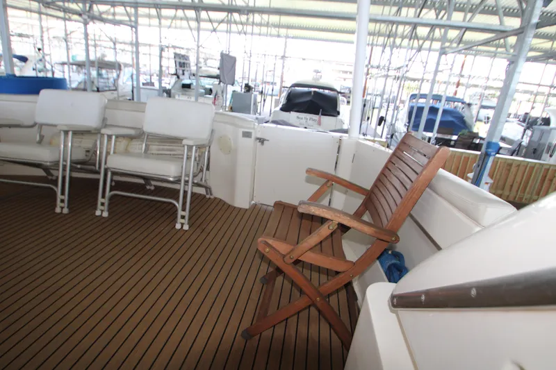 Slide: The Image of 2002 Silverton 43 Motor Yacht deck with seating and wooden chair. - 47