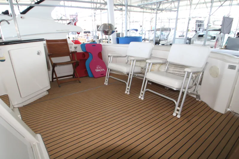 Slide: The Image of 2002 Silverton 43 Motor Yacht deck with chairs and storage, featuring a clean, spacious layout. - 48