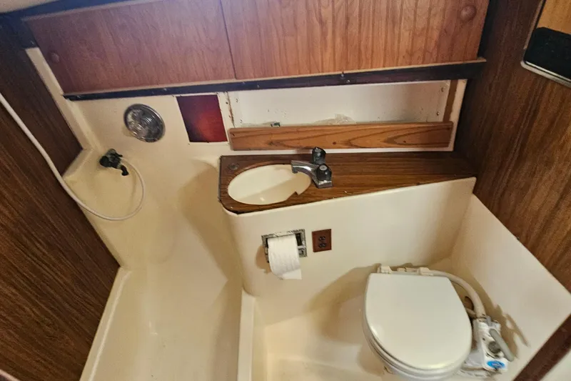 Slide: The Image of 1977 Seafarer 38 yacht bathroom with sink, toilet, and wooden cabinetry. - 15