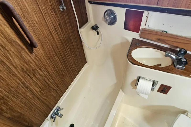 Slide: The Image of 1977 Seafarer 38 boat bathroom with wooden accents and compact sink. - 16