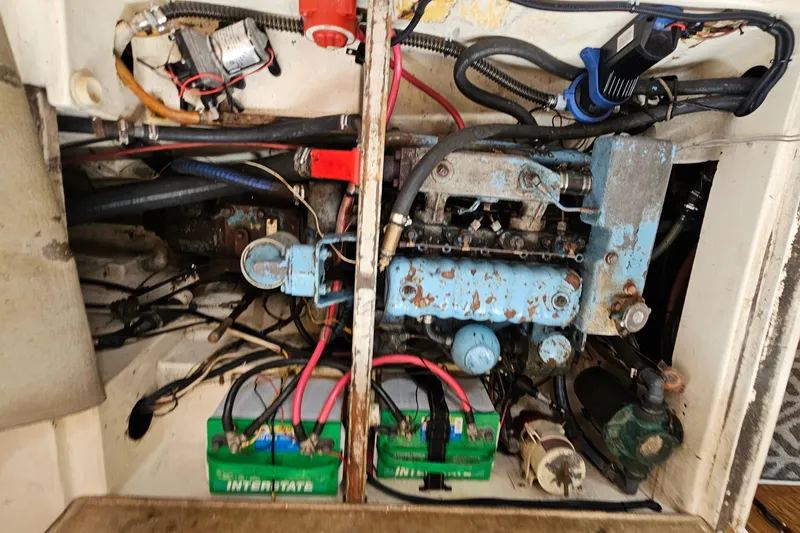 Slide: The Image of Engine compartment of a 1977 Seafarer 38 sailboat with visible wiring and batteries. - 27