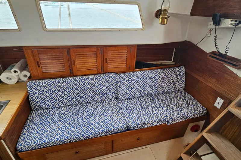 Slide: The Image of 1977 Seafarer 38 interior with blue patterned cushions and wooden cabinetry. - 29