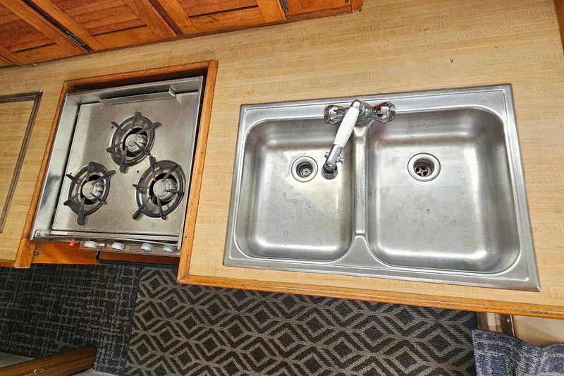 Slide: The Image of 1977 Seafarer 38 yacht kitchen with dual sink and three-burner stove. - 31