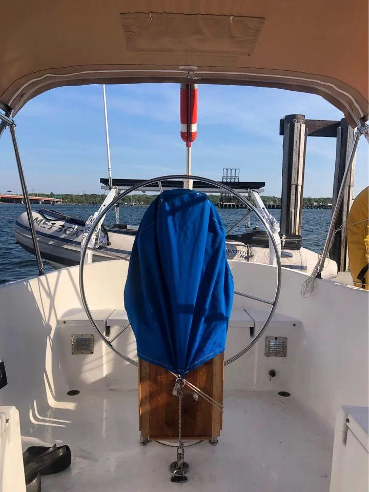 Slide: The Image of 1977 Seafarer 38 sailboat cockpit with covered wheel, docked by the water. - 5