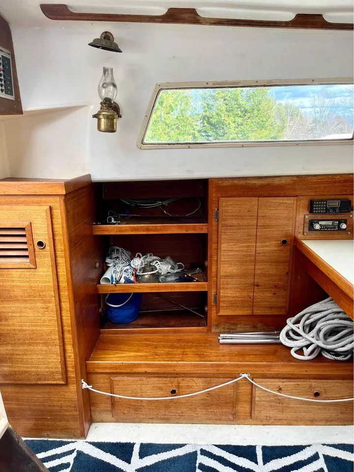 Slide: The Image of 1977 Seafarer 38 interior with wooden cabinets, nautical equipment, and a vintage lamp. - 6