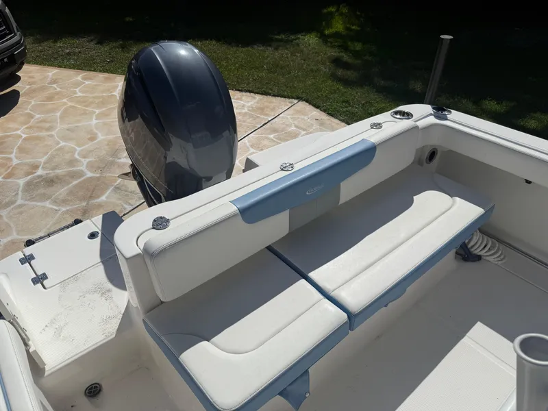 Slide: The Image of 2023 Robalo R222 boat interior with cushioned seating and outboard motor. - 19