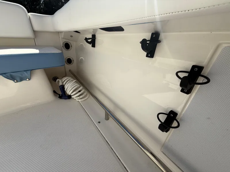 Slide: The Image of 2023 Robalo R222 boat interior with rod holders and coiled rope. - 22