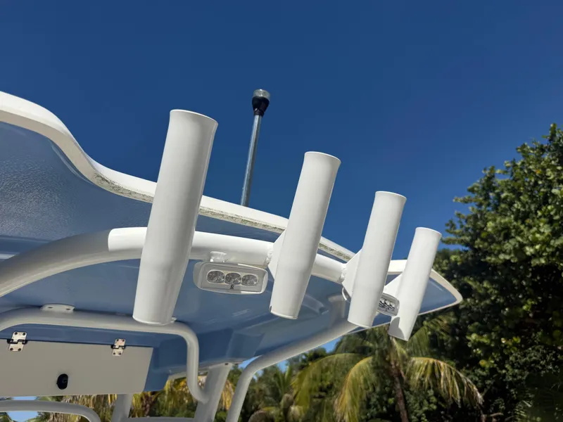 Slide: The Image of 2023 Robalo R222 boat rod holders against clear blue sky. - 26