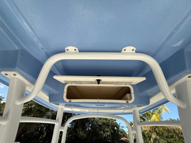 Slide: The Image of 2023 Robalo R222 boat T-top interior with storage compartment, blue and white design. - 28