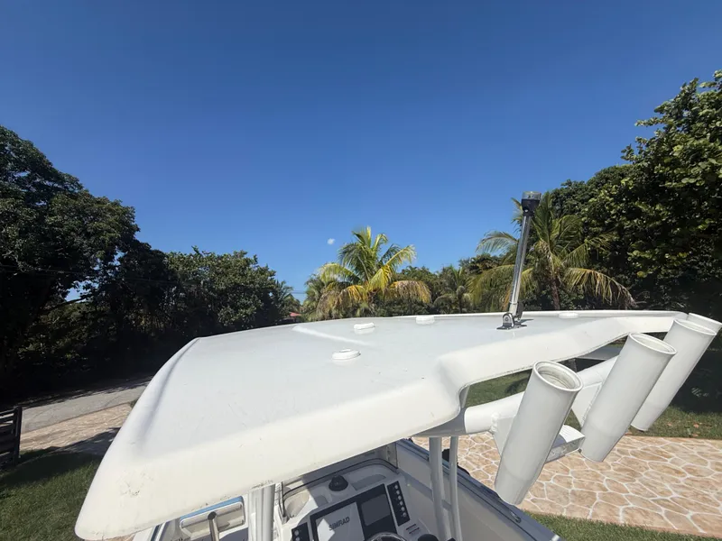 Slide: The Image of 2023 Robalo R222 boat with T-top and rod holders, surrounded by tropical trees. - 30