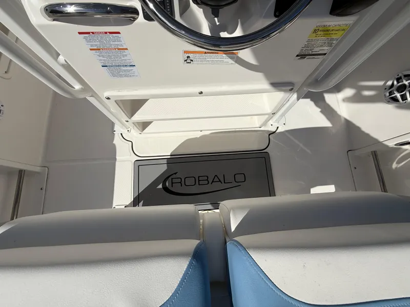 Slide: The Image of 2023 Robalo R222 boat interior with steering wheel and branded floor mat. - 31