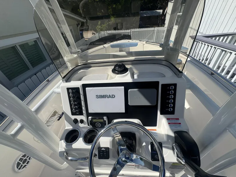 Slide: The Image of 2023 Robalo R222 boat dashboard with Simrad display and steering wheel. - 33