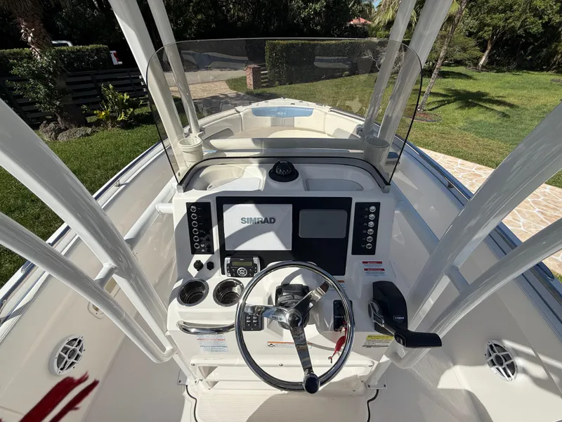Slide: The Image of 2023 Robalo R222 boat dashboard with steering wheel and Simrad display. - 34