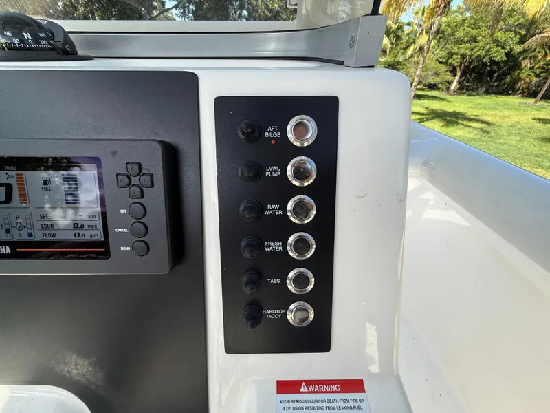 Slide: The Image of Control panel of 2023 Robalo R222 boat with various switches and a digital display. - 40