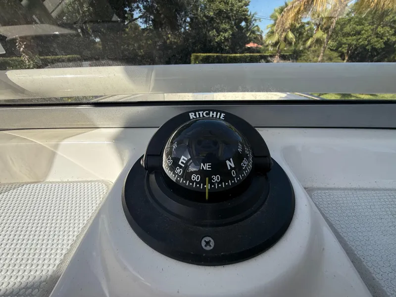 Slide: The Image of Compass on 2023 Robalo R222 boat dashboard, surrounded by tropical scenery. - 46