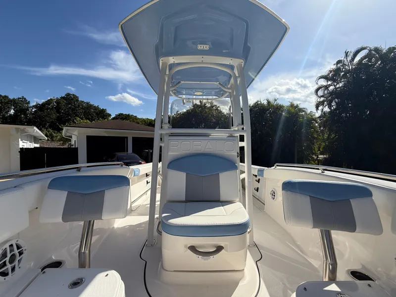Slide: The Image of 2023 Robalo R222 boat interior with blue and white seating under a clear sky. - 47