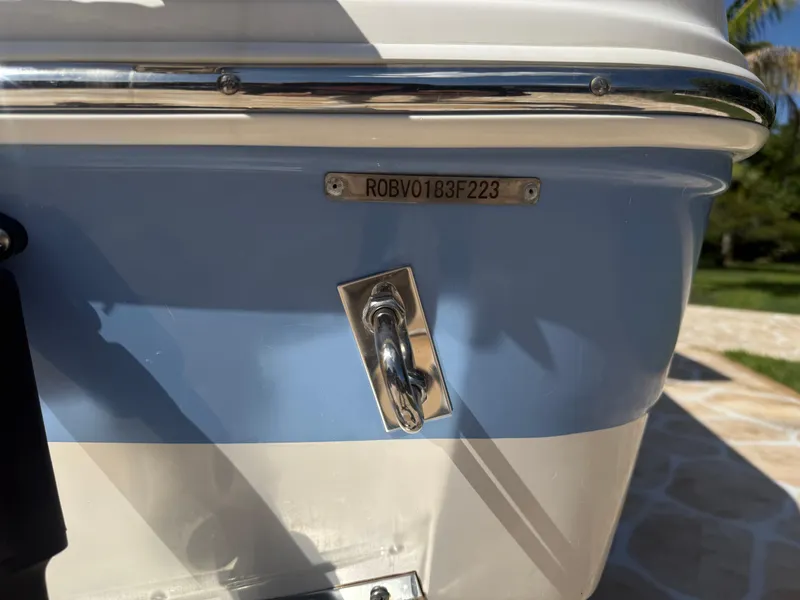Slide: The Image of 2023 Robalo R222 boat stern with identification plate and cleat in sunlight. - 62