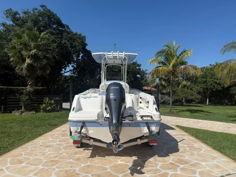 Slide: The Image of 2023 Robalo R222 boat with outboard motor on a sunny driveway, surrounded by palm trees. - 9